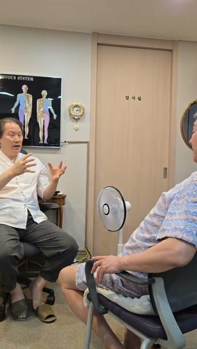 진료실에서 의료진과 환자가 목욕탕 낙상 뒤 생긴 가슴 통증을 상담하는 장면