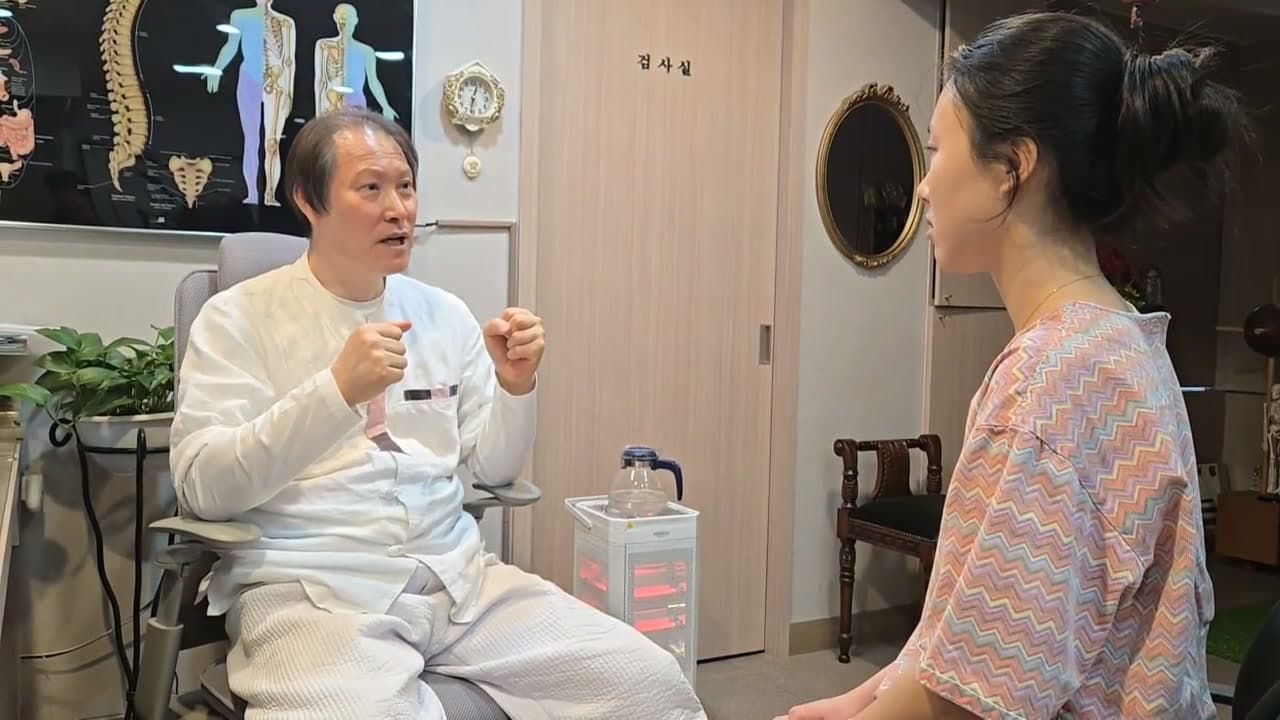 의료진이 손동작을 하며 환자에게 손발 냉감의 정도를 묻는 장면