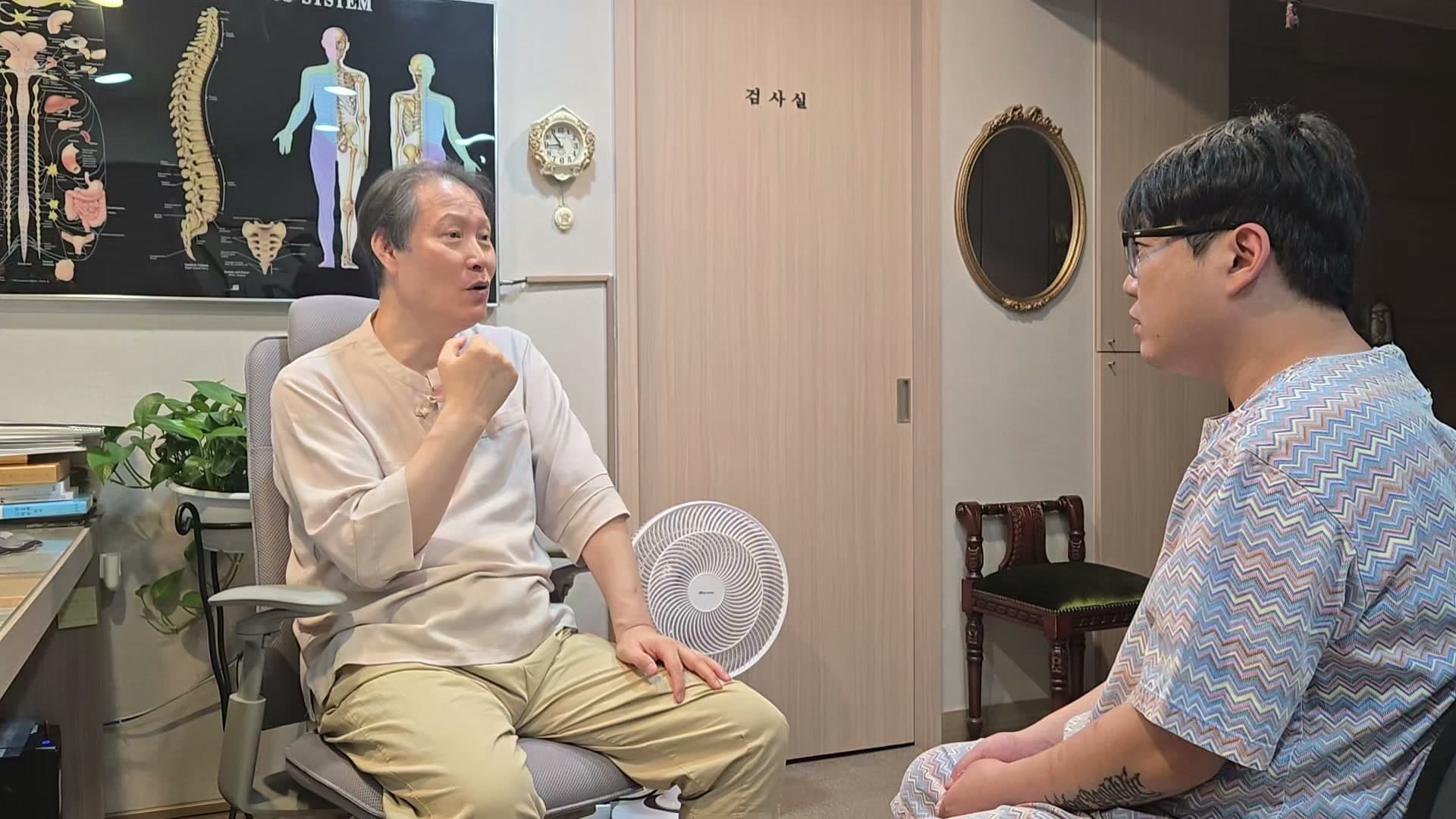 의료진이 얼굴 주변을 손으로 가리키며 환자와 초기 증상을 확인하는 장면