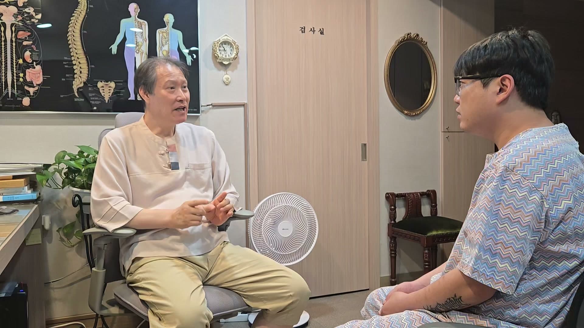 진료실에서 의료진과 환자가 구안와사와 손의 땀, 담석 검사 결과에 관해 이야기하는 장면
