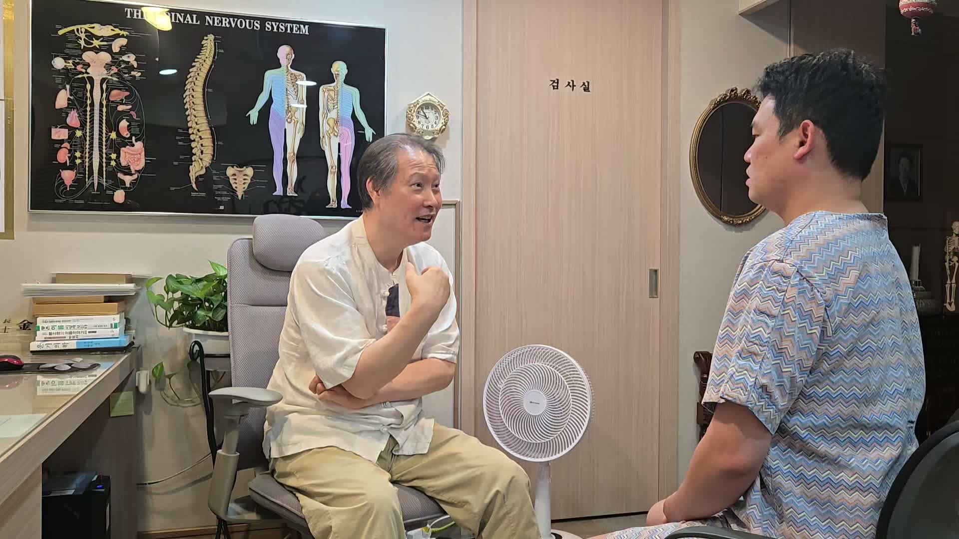 진료실에서 의료진과 환자가 오래 이어진 얼굴 떨림과 당김에 관해 이야기하는 장면