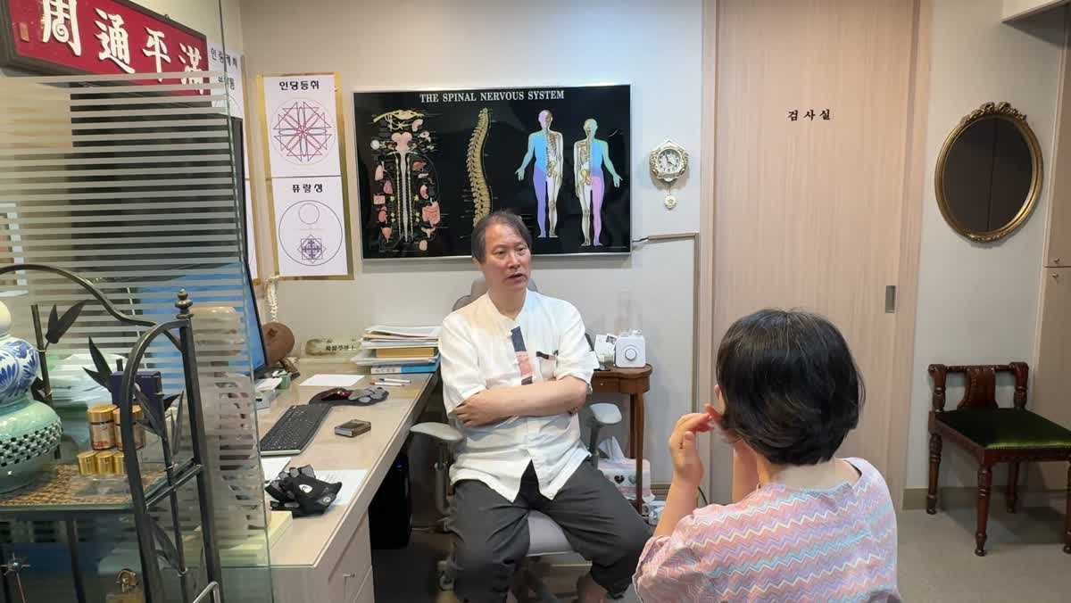 환자가 얼굴에 손을 대며 피부 촉감에 대해 의료진에게 이야기하는 장면