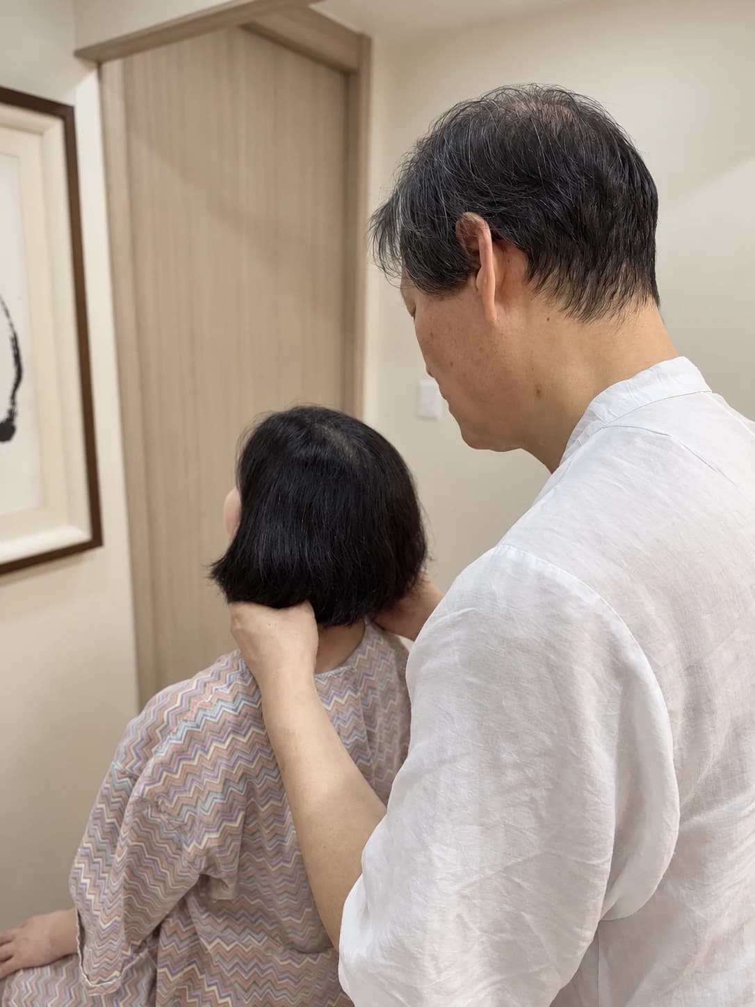 환자의 뒤에서 양쪽 턱관절을 비교진찰하는 모습