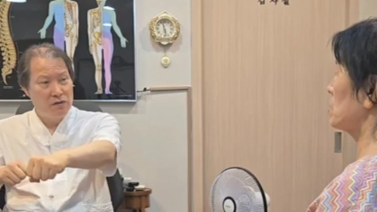 의료진이 무릎을 펴는 동작을 설명하며 환자와 치료 후 상태를 확인하는 장면